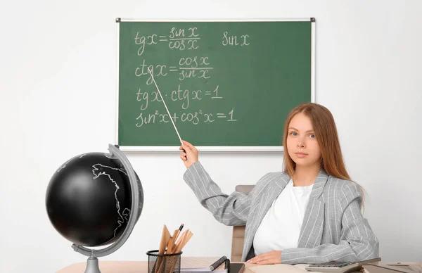 Sınıfta Tahta Masada Oturan Işaretçi Ile Genç Matematik Öğretmeni — Stok fotoğraf