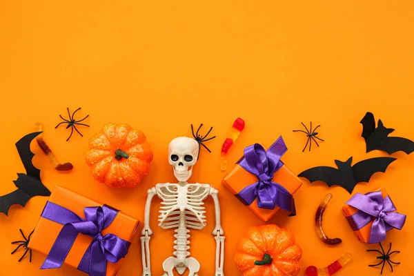 Složení Kostrou Dárkové Krabice Chutné Bonbóny Dýně Halloween Oranžovém Pozadí — Stock fotografie