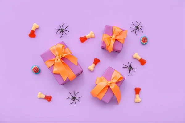 Összetétel Pókokkal Ízletes Cukorkákkal Ajándékdobozokkal Halloween Lila Alapon — Stock Fotó