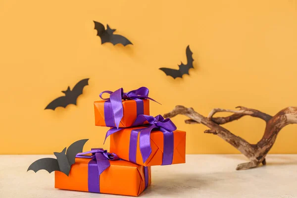 Beautiful gift boxes, wood and bats made of paper for Halloween on orange background