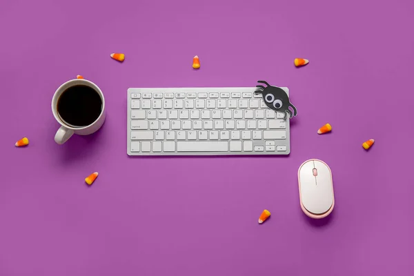 stock image Composition with modern computer keyboard, mouse, cup of coffee and tasty candy corns for Halloween on purple background