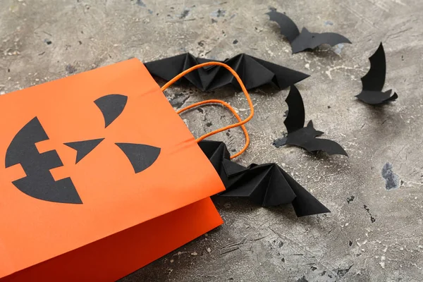 Composition with shopping bag and bats for Halloween on grunge grey background, closeup