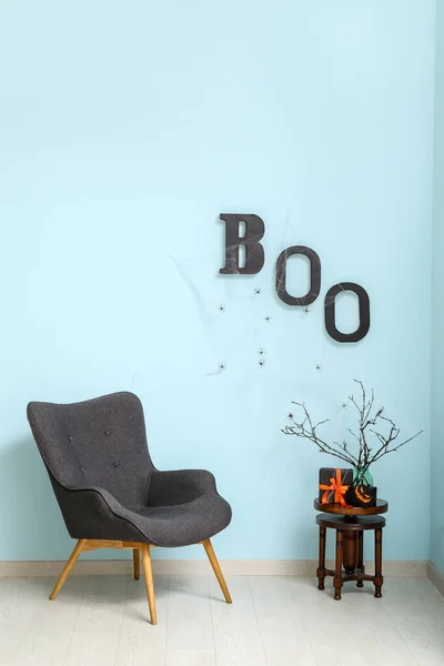 Fotel Stół Pudełkami Prezenty Halloween Tekst Boo Wiszące Niebieskiej Ścianie — Zdjęcie stockowe