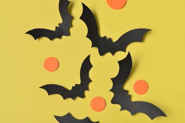 黄色の背景のハロウィーンパーティーのための紙コウモリ — ストック写真