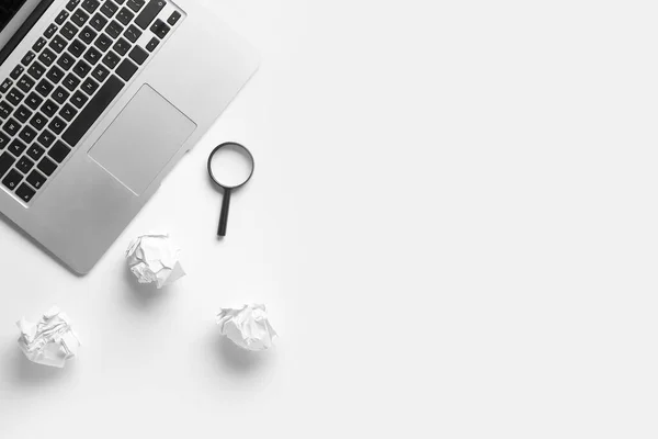 stock image Modern laptop, crumpled paper balls and magnifier on white background