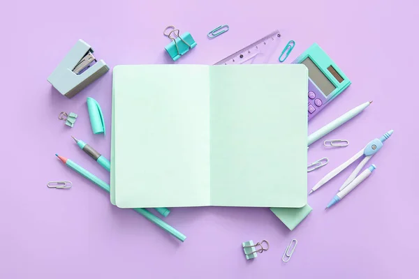 带有空白笔记本和紫色背景的不同学校文具的作文 — 图库照片