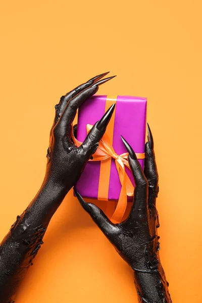 Zwarte Handen Van Heks Met Geschenkdoos Oranje Achtergrond Halloween Viering — Stockfoto