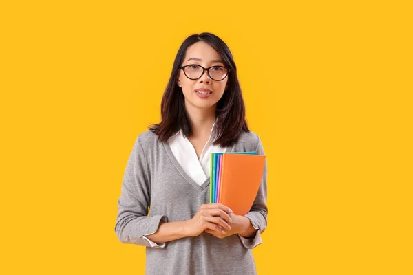 Female Asian Teacher Copybooks Yellow Background — Stock Photo, Image