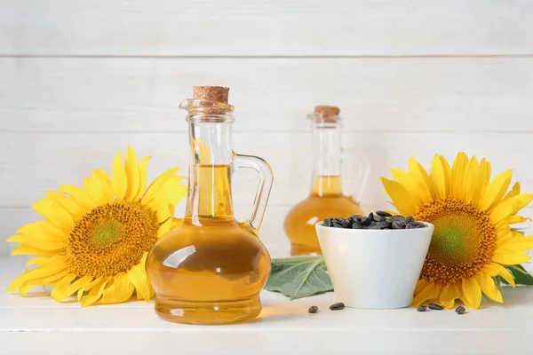 Dekanter Mit Sonnenblumenöl Und Schale Mit Samen Auf Weißem Holzhintergrund — Stockfoto