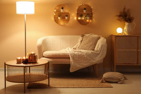 スタイリッシュなソファーとテーブルにろうそくを燃やすリビングルームのモダンなインテリア — ストック写真