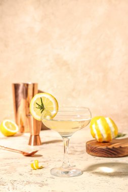 Hafif arkaplanda bir bardak martini ve limon.
