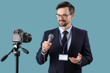 Mavi arka planda mikrofon kayıt videosu olan erkek gazeteci