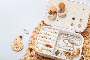 Beyaz arka planda şık mücevherleri olan hasır kaplama ve düzenleyici