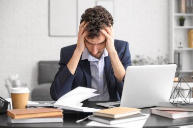 Ofiste çalışan stresli genç iş adamı