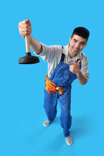 Young Male Plumber Pointing Plunger Blue Background — Stock Photo, Image
