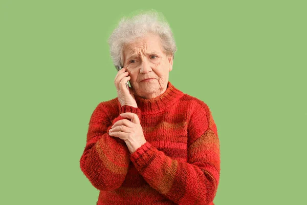 Грустная Пожилая Женщина Разговаривает Мобильному Телефону Зеленом Фоне — стоковое фото