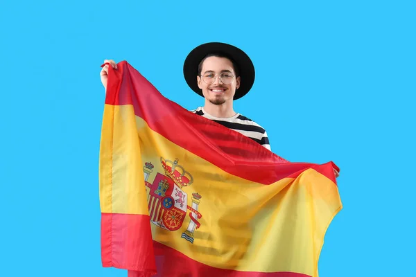 略带蓝色背景 拿着西班牙国旗的英俊年轻人 — 图库照片
