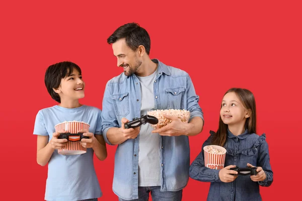 Małe Dzieci Ojcem Popcornem Grające Gry Wideo Czerwonym Tle — Zdjęcie stockowe