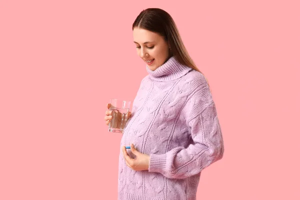 Młoda Kobieta Ciąży Szklanką Wody Tabletką Kwasu Foliowego Różowym Tle — Zdjęcie stockowe