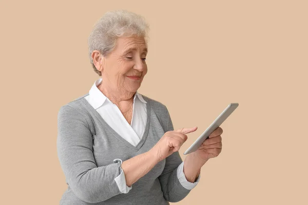 Mulher Sênior Usando Computador Tablet Fundo Bege — Fotografia de Stock