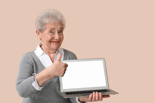 Mulher Sênior Com Laptop Mostrando Polegar Para Cima Fundo Bege — Fotografia de Stock
