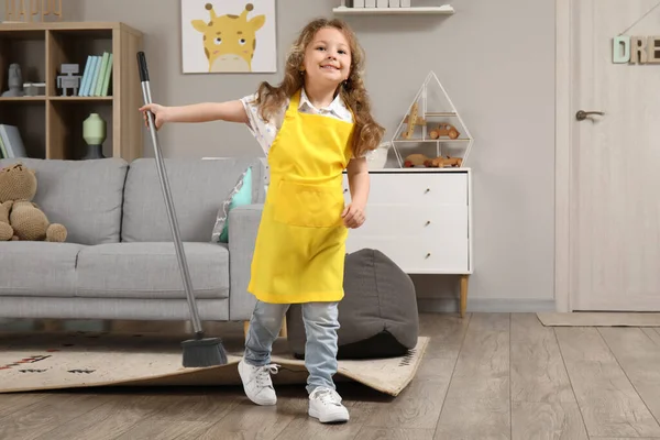 stock image Cute little girl with broom at home