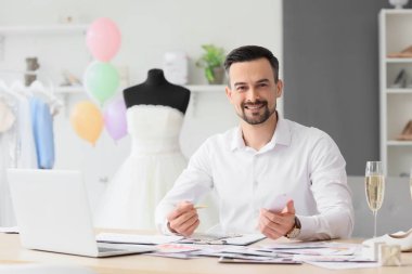 Erkek düğün organizatörü ofiste renk paletleriyle çalışıyor.