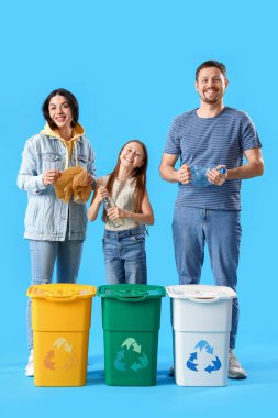 Aile çöpleri mavi arka planda geri dönüşüm kutularıyla sıralıyor