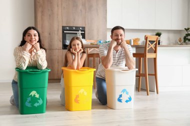 Mutfakta çöp bidonları olan bir aile.