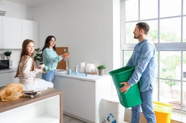 Evdeki çöp kutusunda sıralamadan önce aile cam şişesi yıkıyor.