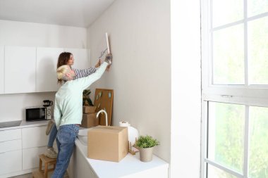 Taşındığı gün mutfakta posterleri olan genç bir çift.