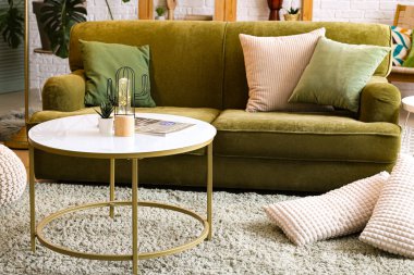 Işıldayan lamba, masa ve kanepeli oturma odasının içi.