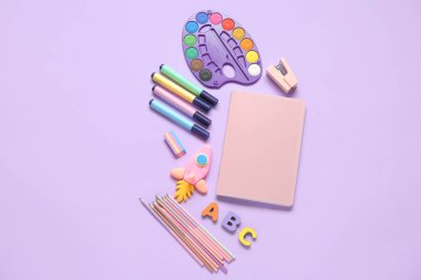 Değişik kırtasiye malzemesi ve eflatun kaplamalı ahşap harflerden yapılmış roket.