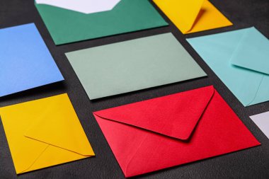 Koyu arkaplanda renkli zarflar olan kompozisyon, yakın plan