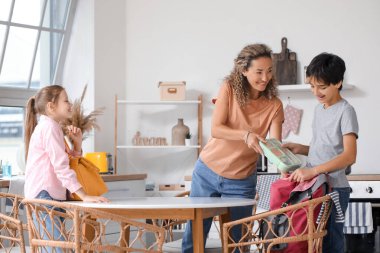 Anne ve küçük çocukları mutfakta öğle yemeği hazırlıyorlar.