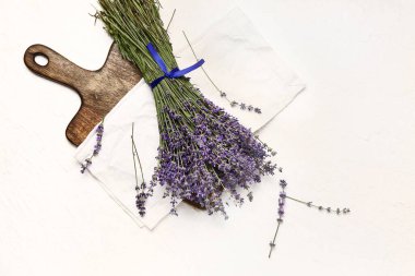 Açık arkaplanda bir buket güzel lavanta çiçeği olan tahta.