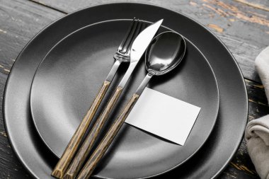 Siyah ahşap arka planda kartı olan zarif modern masa.