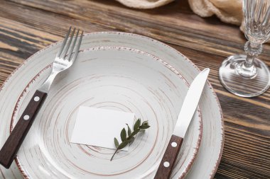 Kahverengi ahşap arka planda kartı olan modern masa ayarları