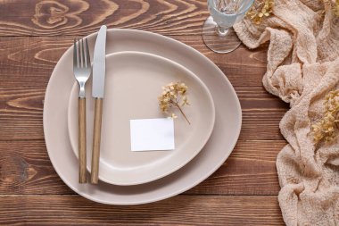 Kahverengi ahşap arka planda kartı olan modern masa ayarları