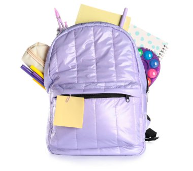 Not defterleri ve beyaz arka planda farklı kırtasiye malzemeleriyle leylak rengi okul çantası.