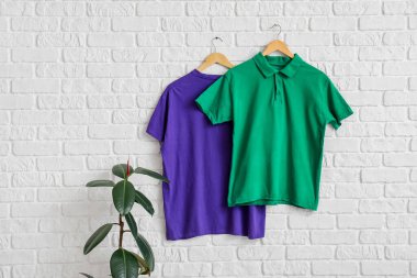 Beyaz tuğla duvarda asılı şık tişörtler