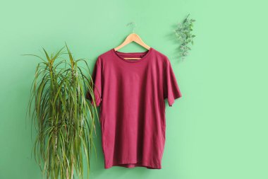 Yeşil arkaplanda asılı şık kırmızı tişört