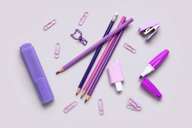 Açık arkaplanda renkli kalemlerle farklı kırtasiye setleri