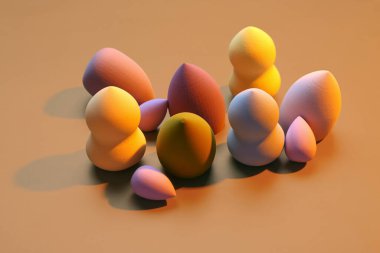 Kahverengi arka planda farklı makyaj süngerleri