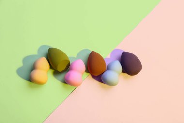 Renkli arkaplanda farklı makyaj süngerleri