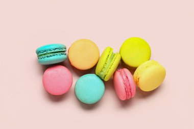 Pembe arka planda farklı tatlı badem kurabiyeleri.