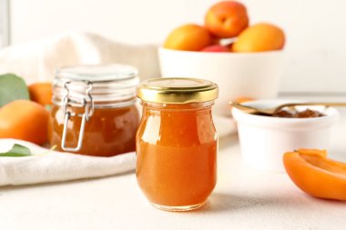 Beyaz arka planda tatlı kayısı reçeli kavanoz