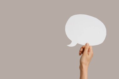 Gri arkaplanda konuşma baloncuğu olan bir kadın eli