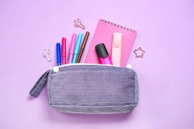 Mor arka planda farklı okul kırtasiyesine sahip kalem kutusu