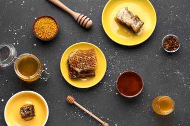 Tatlı bal, taraklar ve siyah arkaplanda arı poleni